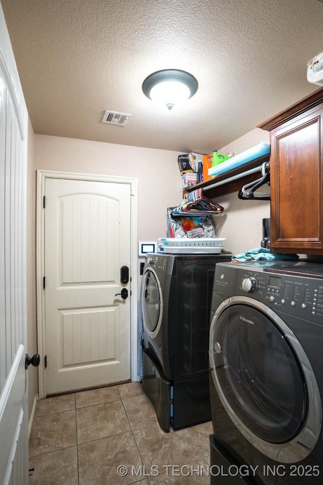 12901 N 124th E Pl, Collinsville, OK 74021 - washroom with washing machine and clothes dryer, a textured ceiling, light tile patterned floors, and cabinet space