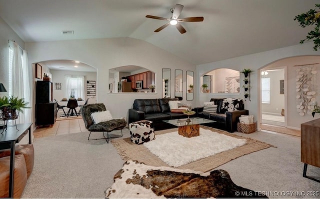 11001 N 146th E Ave, Owasso, OK 74055 - living room featuring light carpet, ceiling fan, vaulted ceiling, and arched walkways