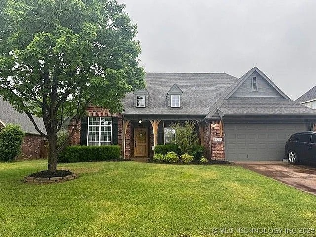 11725 S Vine Pl S, Jenks, OK 74037 - view of front of home with an attached garage, a front yard, driveway, and brick siding
