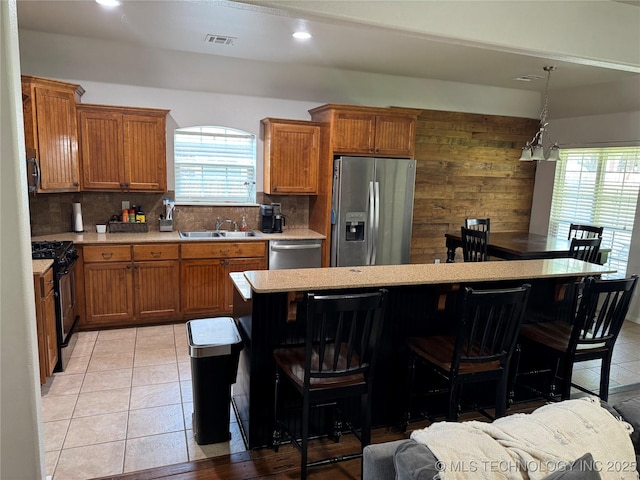 11725 S Vine Pl S, Jenks, OK 74037 - kitchen featuring appliances with stainless steel finishes, plenty of natural light, light countertops, brown cabinetry, and recessed lighting