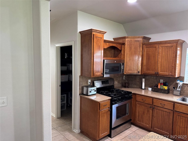 11725 S Vine Pl S, Jenks, OK 74037 - kitchen featuring appliances with stainless steel finishes, light tile patterned floors, lofted ceiling, and tasteful backsplash