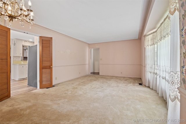 5153 S Marion Ave, Tulsa, OK 74135 - carpeted spare room with a chandelier and ornamental molding