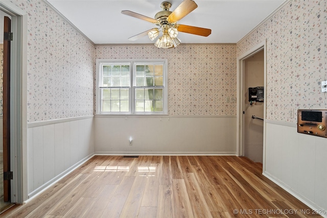 5153 S Marion Ave, Tulsa, OK 74135 - empty room featuring ornamental molding, wallpapered walls, light wood finished floors, a wainscoted wall, and a ceiling fan