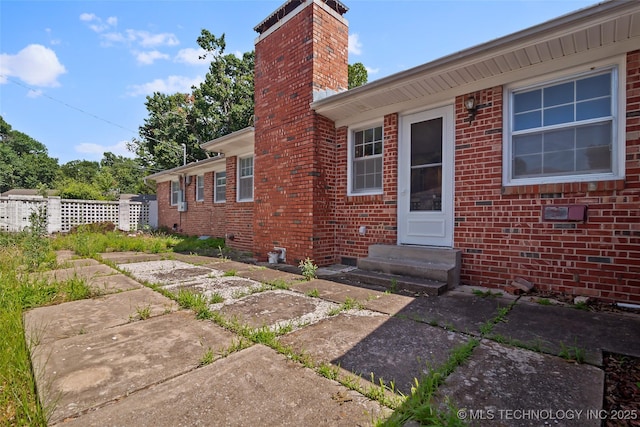 5153 S Marion Ave, Tulsa, OK 74135 - doorway to property featuring a chimney and brick siding