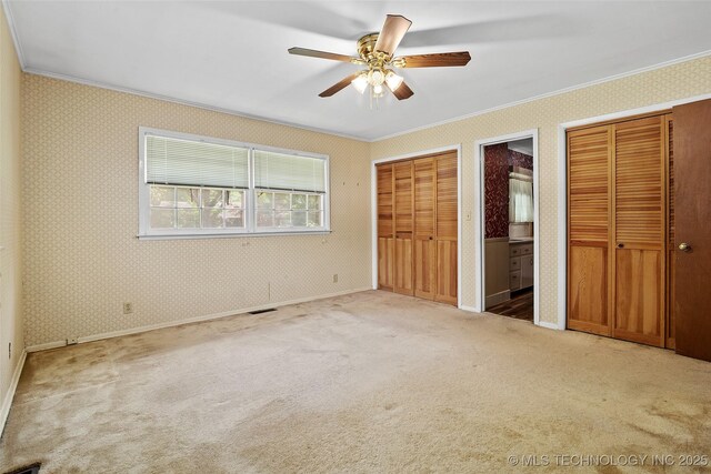 5153 S Marion Ave, Tulsa, OK 74135 - unfurnished bedroom featuring ornamental molding, multiple closets, carpet flooring, ensuite bathroom, and ceiling fan