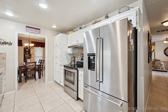 2807 W Atlanta Pl, Broken Arrow, OK 74012 - kitchen featuring appliances with stainless steel finishes, under cabinet range hood, light tile patterned floors, white cabinetry, and a chandelier