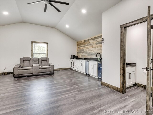 11446 Mary Knox Dr, Beggs, OK 74421 - living room featuring wine cooler, wet bar, ceiling fan, vaulted ceiling, and wood finished floors