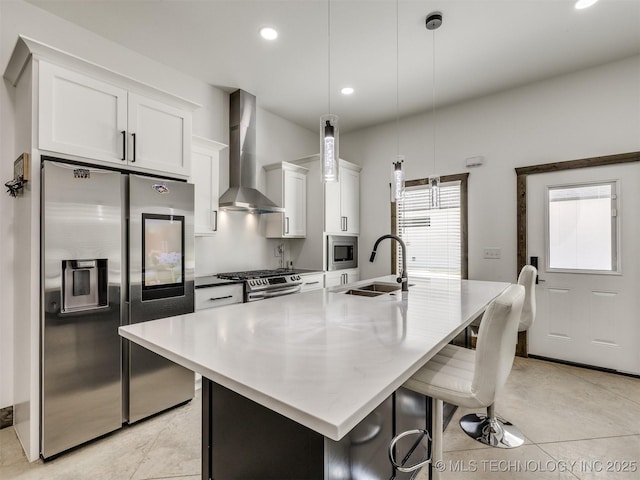11446 Mary Knox Dr, Beggs, OK 74421 - kitchen featuring stainless steel appliances, wall chimney exhaust hood, white cabinets, a kitchen island with sink, and a breakfast bar