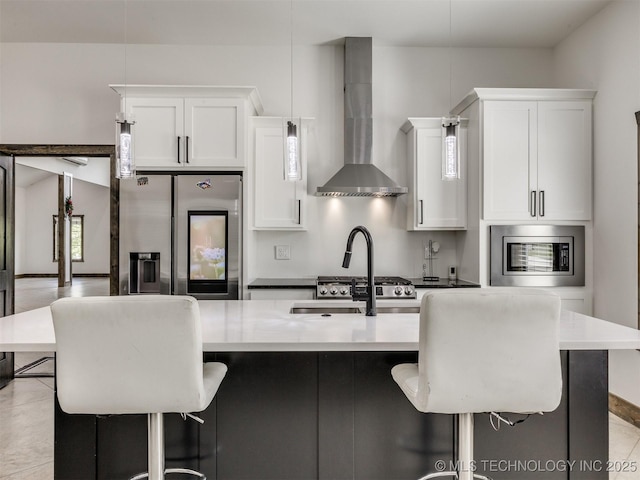 11446 Mary Knox Dr, Beggs, OK 74421 - kitchen featuring appliances with stainless steel finishes, wall chimney exhaust hood, a kitchen breakfast bar, and a kitchen island with sink
