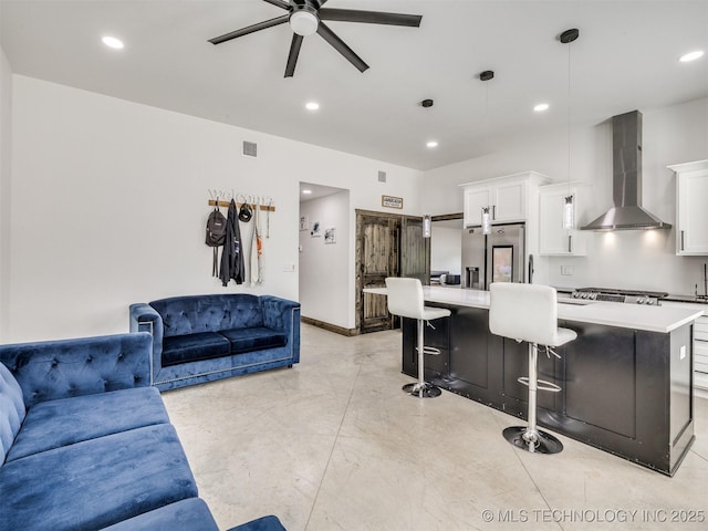 11446 Mary Knox Dr, Beggs, OK 74421 - kitchen with wall chimney exhaust hood, open floor plan, stainless steel fridge, ceiling fan, and a breakfast bar