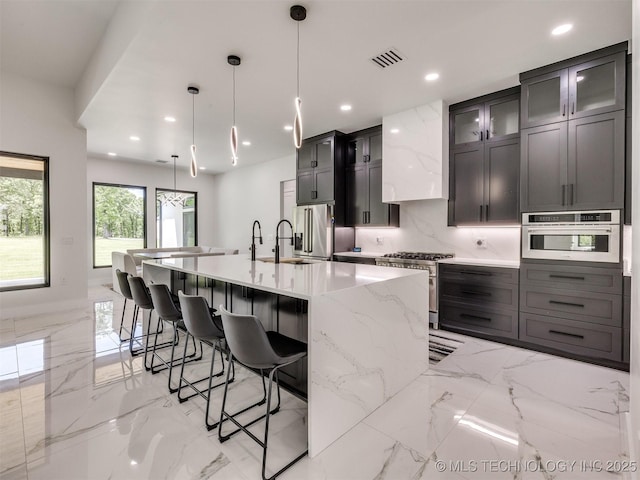 11446 Mary Knox Dr, Beggs, OK 74421 - kitchen with stainless steel appliances, light marble finish floors, a breakfast bar, a large island with sink, and recessed lighting