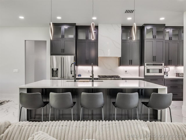 11446 Mary Knox Dr, Beggs, OK 74421 - kitchen with light marble finish floors, stainless steel appliances, a center island with sink, recessed lighting, and glass insert cabinets