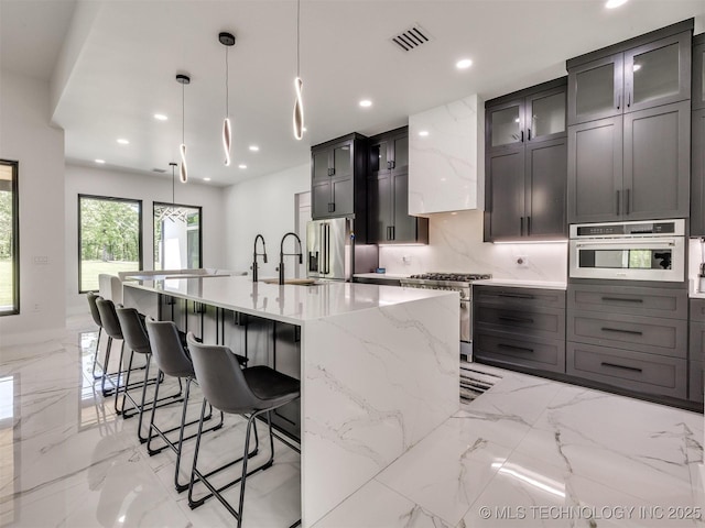 11446 Mary Knox Dr, Beggs, OK 74421 - kitchen with appliances with stainless steel finishes, light marble finish flooring, a breakfast bar, recessed lighting, and light stone countertops