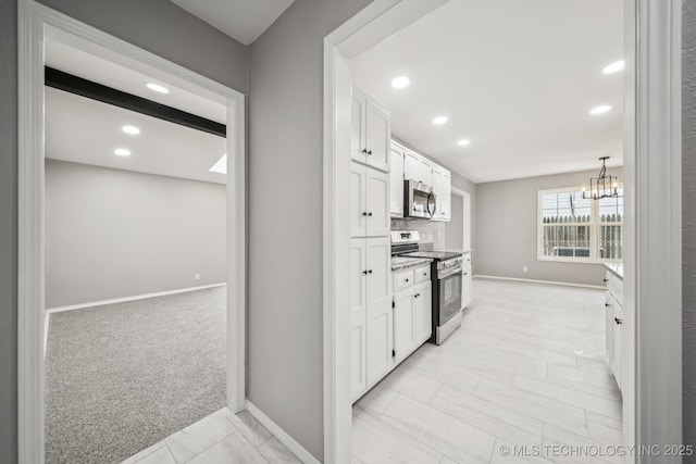 2712 S Fir Ave, Broken Arrow, OK 74012 - kitchen with appliances with stainless steel finishes, white cabinets, recessed lighting, light marble finish floors, and a chandelier