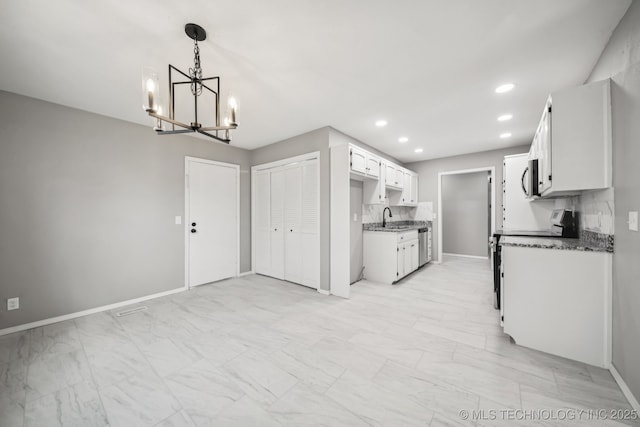 2712 S Fir Ave, Broken Arrow, OK 74012 - kitchen with appliances with stainless steel finishes, a chandelier, light marble finish flooring, recessed lighting, and dark countertops