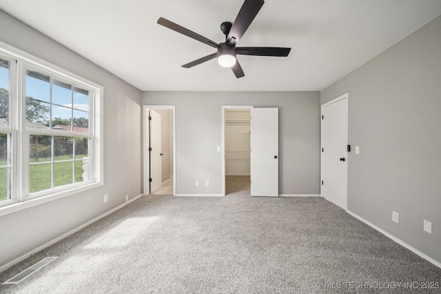 2712 S Fir Ave, Broken Arrow, OK 74012 - unfurnished bedroom featuring carpet flooring, a spacious closet, and a ceiling fan