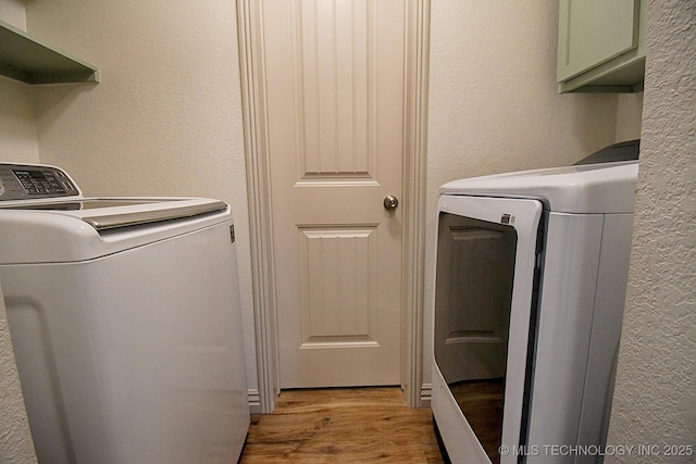 96539 S 4550th Rd, Vian, OK 74962 - laundry room featuring washing machine and clothes dryer, cabinet space, light wood-type flooring, and a textured wall