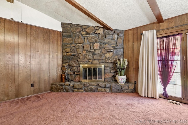 12452 E 36th St, Tulsa, OK 74146 - unfurnished living room with wooden walls, a textured ceiling, carpet floors, and a stone fireplace
