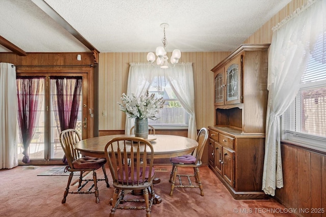 12452 E 36th St, Tulsa, OK 74146 - dining area with light colored carpet, a textured ceiling, a chandelier, wooden walls, and plenty of natural light