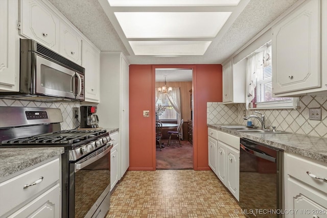 12452 E 36th St, Tulsa, OK 74146 - kitchen with appliances with stainless steel finishes, a chandelier, white cabinetry, and light countertops
