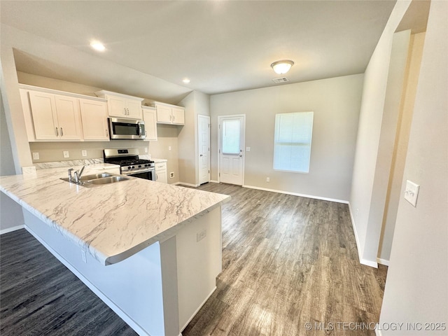 8314 E 162nd St S, Bixby, OK 74008 - kitchen featuring stainless steel appliances, dark wood-style floors, white cabinets, a peninsula, and a kitchen breakfast bar