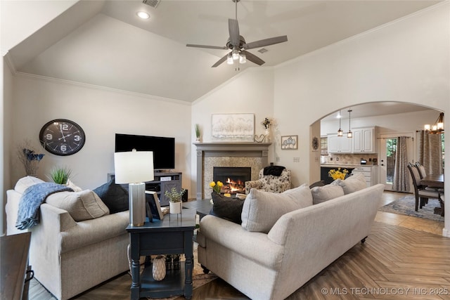2611 S 15th Pl, Broken Arrow, OK 74012 - living room featuring arched walkways, a ceiling fan, a tile fireplace, crown molding, and vaulted ceiling