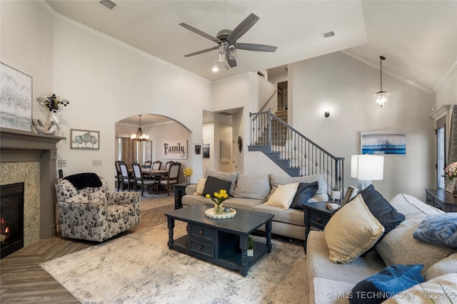 2611 S 15th Pl, Broken Arrow, OK 74012 - living area with high vaulted ceiling, a tiled fireplace, stairway, arched walkways, and ceiling fan