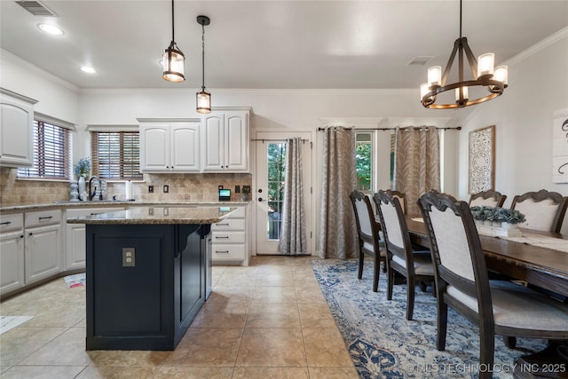 2611 S 15th Pl, Broken Arrow, OK 74012 - kitchen with a chandelier, healthy amount of natural light, decorative backsplash, crown molding, and white cabinetry