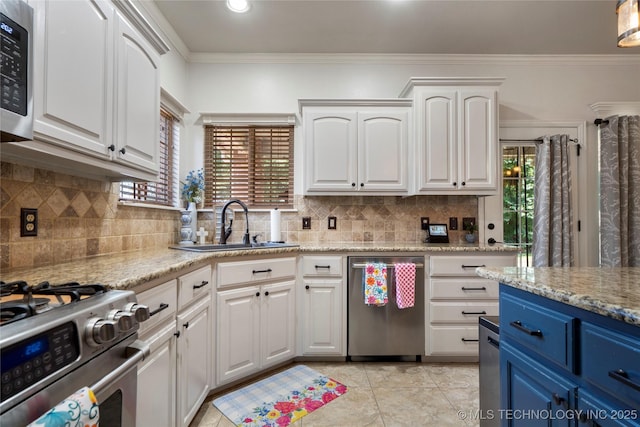 2611 S 15th Pl, Broken Arrow, OK 74012 - kitchen with appliances with stainless steel finishes, blue cabinetry, white cabinets, crown molding, and backsplash