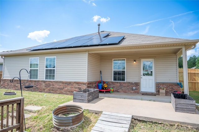 1330 Panther Ln, Sapulpa, OK 74066 - back of property featuring brick siding, solar panels, and a patio