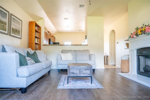 1330 Panther Ln, Sapulpa, OK 74066 - living room with arched walkways, wood finished floors, a fireplace with raised hearth, and lofted ceiling