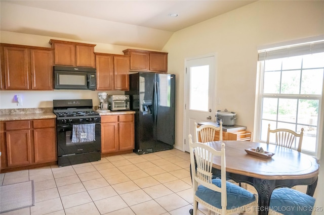1330 Panther Ln, Sapulpa, OK 74066 - kitchen with black appliances, brown cabinetry, lofted ceiling, and light countertops