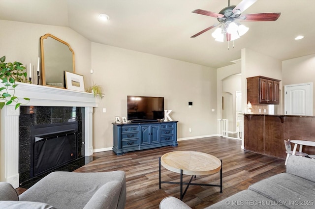 1801 E Montgomery St, Broken Arrow, OK 74012 - living room featuring vaulted ceiling, dark wood finished floors, a ceiling fan, a tile fireplace, and recessed lighting