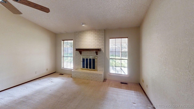1124 Surrey Dr, Ardmore, OK 73401 - unfurnished living room with a textured ceiling, carpet floors, ceiling fan, a fireplace, and a textured wall