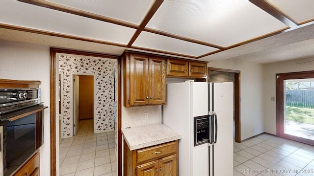 1124 Surrey Dr, Ardmore, OK 73401 - kitchen with white refrigerator with ice dispenser, oven, light tile patterned floors, and light countertops