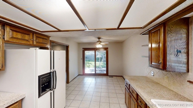 1124 Surrey Dr, Ardmore, OK 73401 - kitchen with white fridge with ice dispenser, light countertops, decorative backsplash, and brown cabinets