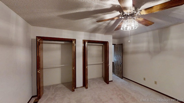 1124 Surrey Dr, Ardmore, OK 73401 - unfurnished bedroom with two closets, light colored carpet, a ceiling fan, and a textured ceiling