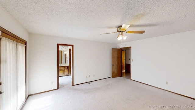 1124 Surrey Dr, Ardmore, OK 73401 - unfurnished bedroom featuring light carpet, ensuite bathroom, ceiling fan, a closet, and a textured ceiling