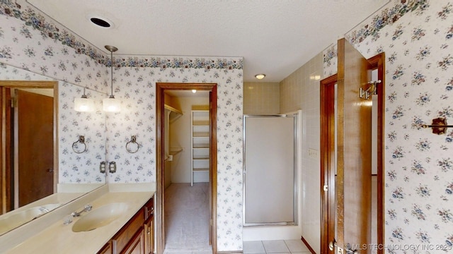 1124 Surrey Dr, Ardmore, OK 73401 - bathroom featuring vanity, a shower stall, a spacious closet, a textured ceiling, and tile patterned floors