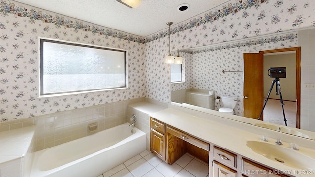 1124 Surrey Dr, Ardmore, OK 73401 - full bath with wallpapered walls, vanity, a bath, tile patterned flooring, and a textured ceiling