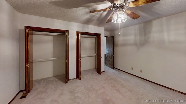 1124 Surrey Dr, Ardmore, OK 73401 - unfurnished bedroom featuring two closets, light carpet, a textured ceiling, and a ceiling fan