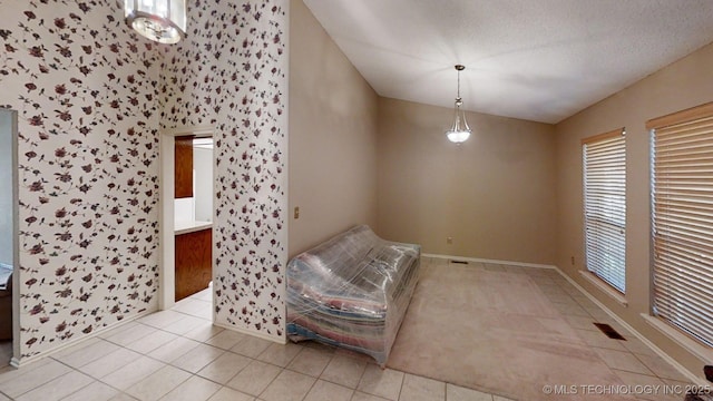 1124 Surrey Dr, Ardmore, OK 73401 - unfurnished room with plenty of natural light, lofted ceiling, light tile patterned floors, and wallpapered walls