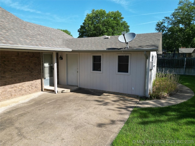 1124 Surrey Dr, Ardmore, OK 73401 - back of house featuring a shingled roof, a patio area, and brick siding