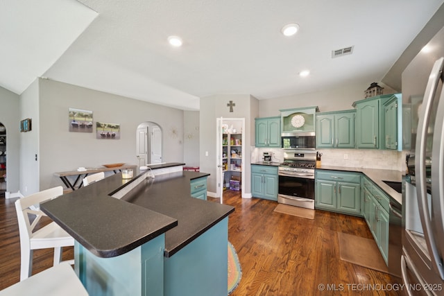 921 S 75th St, Broken Arrow, OK 74014 - kitchen with appliances with stainless steel finishes, a kitchen breakfast bar, dark wood-style floors, a kitchen island, and decorative backsplash