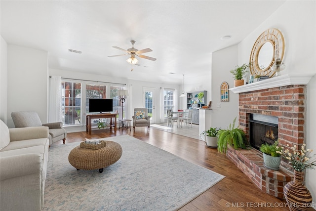 14907 E 88th St N, Owasso, OK 74055 - living area with ceiling fan, wood finished floors, and a fireplace