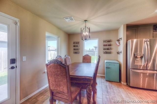 12005 E 108th Pl N, Owasso, OK 74055 - dining area with a chandelier, light wood-style flooring, and healthy amount of natural light