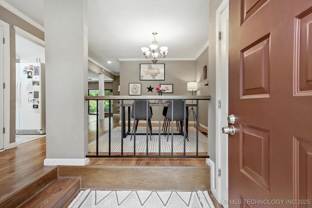 2955 E 84th St S Unit 65, Tulsa, OK 74137 - foyer entrance featuring ornamental molding, a chandelier, wood finished floors, and a textured ceiling