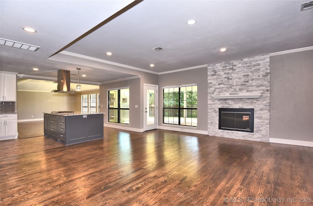7020 E 89th St, Tulsa, OK 74133 - unfurnished living room featuring crown molding, a stone fireplace, recessed lighting, and dark wood-style floors