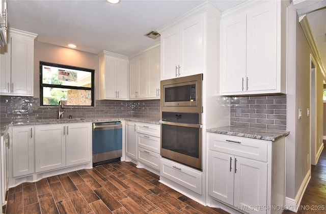 7020 E 89th St, Tulsa, OK 74133 - kitchen with stainless steel appliances, white cabinetry, light stone counters, recessed lighting, and tasteful backsplash