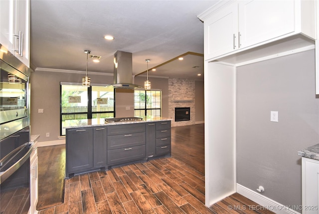 7020 E 89th St, Tulsa, OK 74133 - kitchen with island exhaust hood, appliances with stainless steel finishes, white cabinetry, light stone counters, and ornamental molding